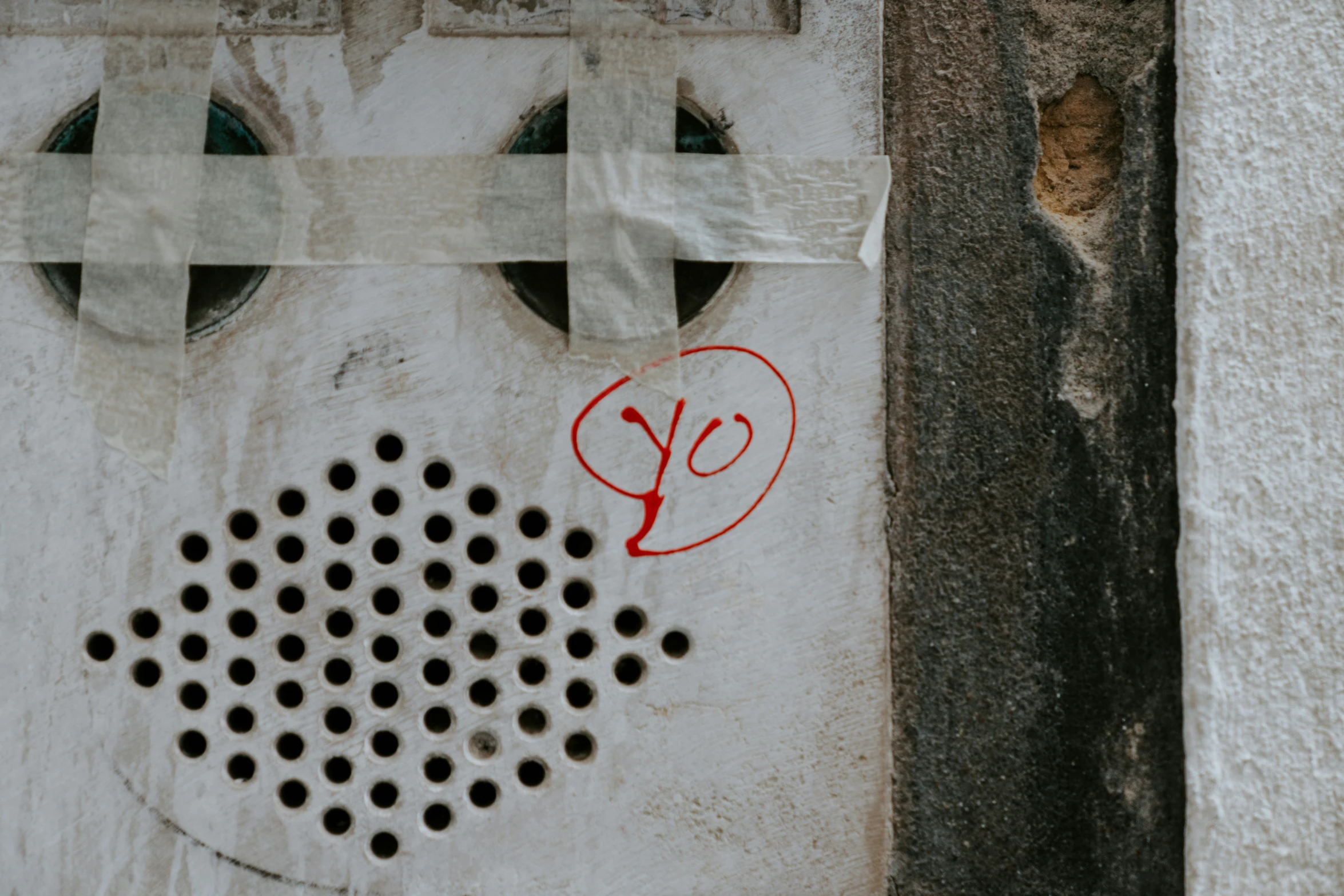 a sign attached to a wall with holes