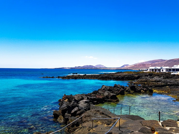 the beautiful blue ocean is near the rocky shore