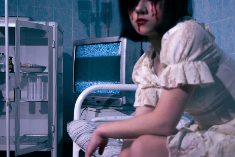 a woman with makeup and tears sits near an open medical cabinet