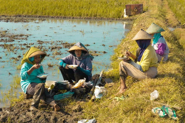 two ladies who are sitting on the side of a dirt road