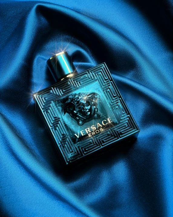 an elegant perfume bottle sits on blue silk