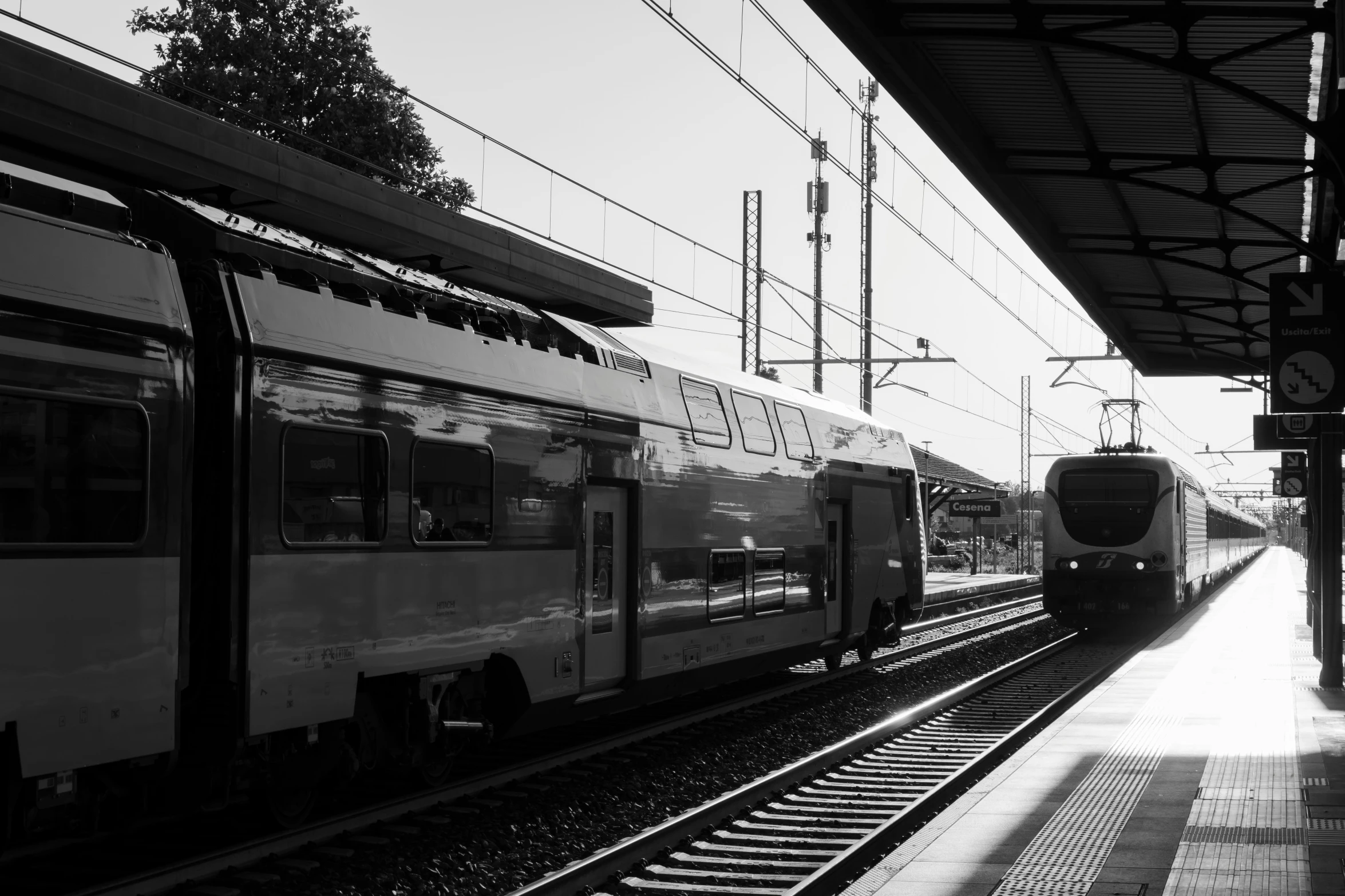 two trains are next to each other in black and white