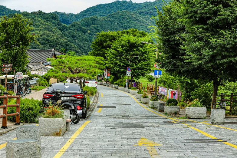 a motorcycle parked along side a very narrow road