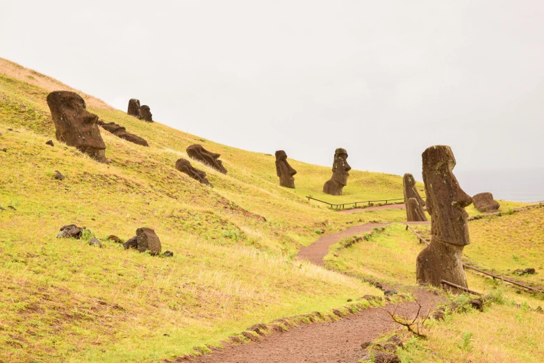 there are statues on the hillside and one is on a bicycle