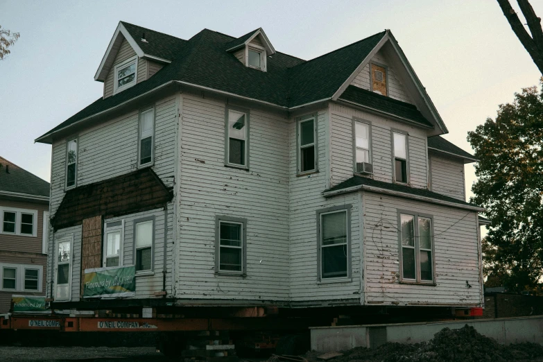 a white house that is under construction and has broken windows