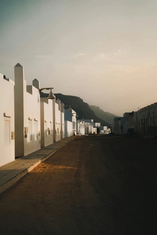 a road is paved by several white buildings