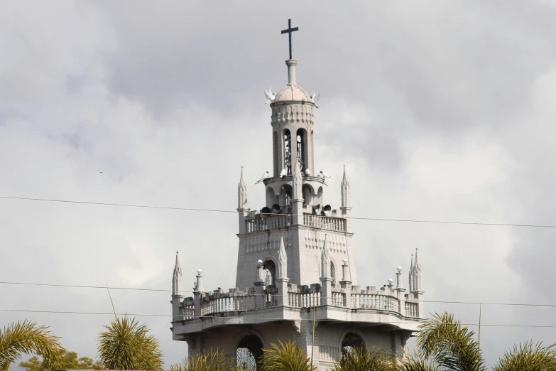 a tall building with a steeple next to trees