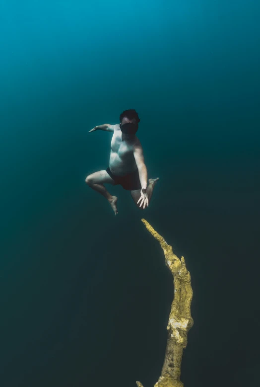 a man in a swim suit diving in the ocean