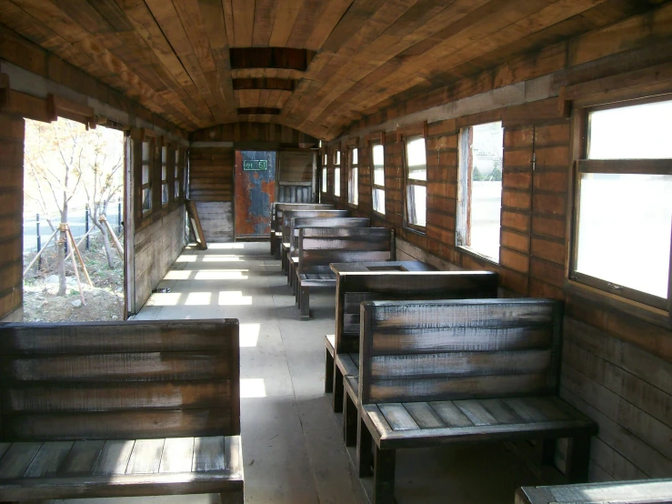 some wooden benches by windows and wood walls