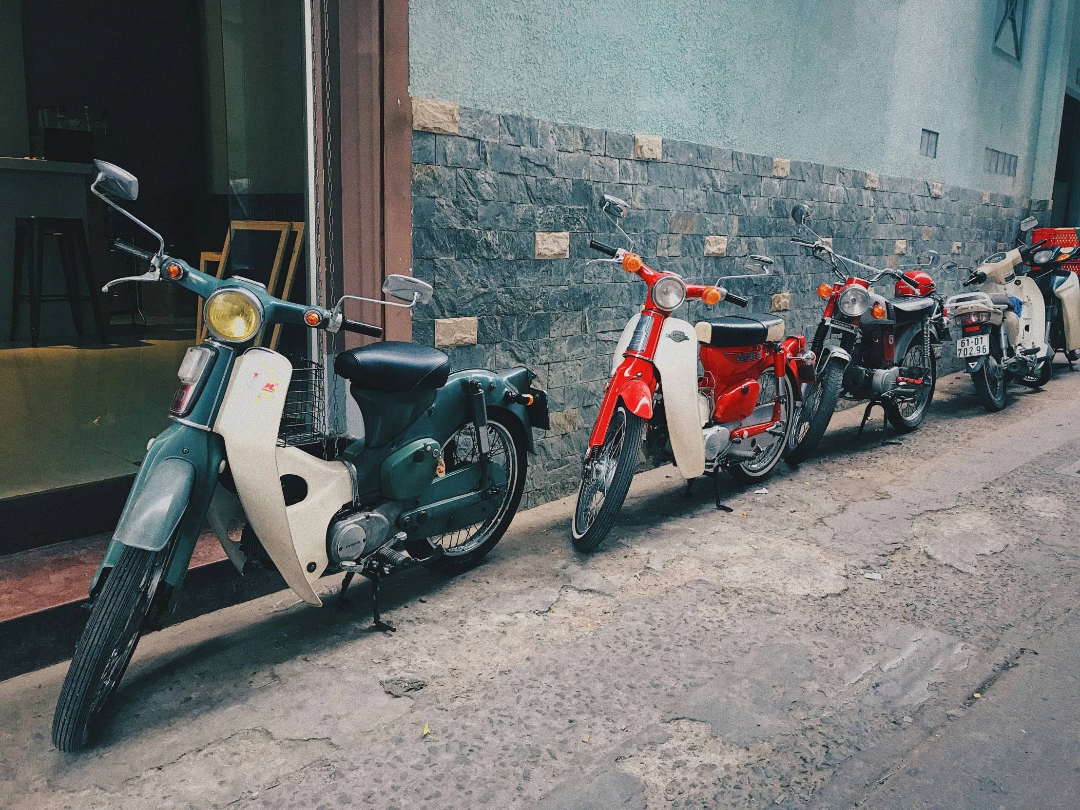 several parked motorcycles lined up by the side of the road