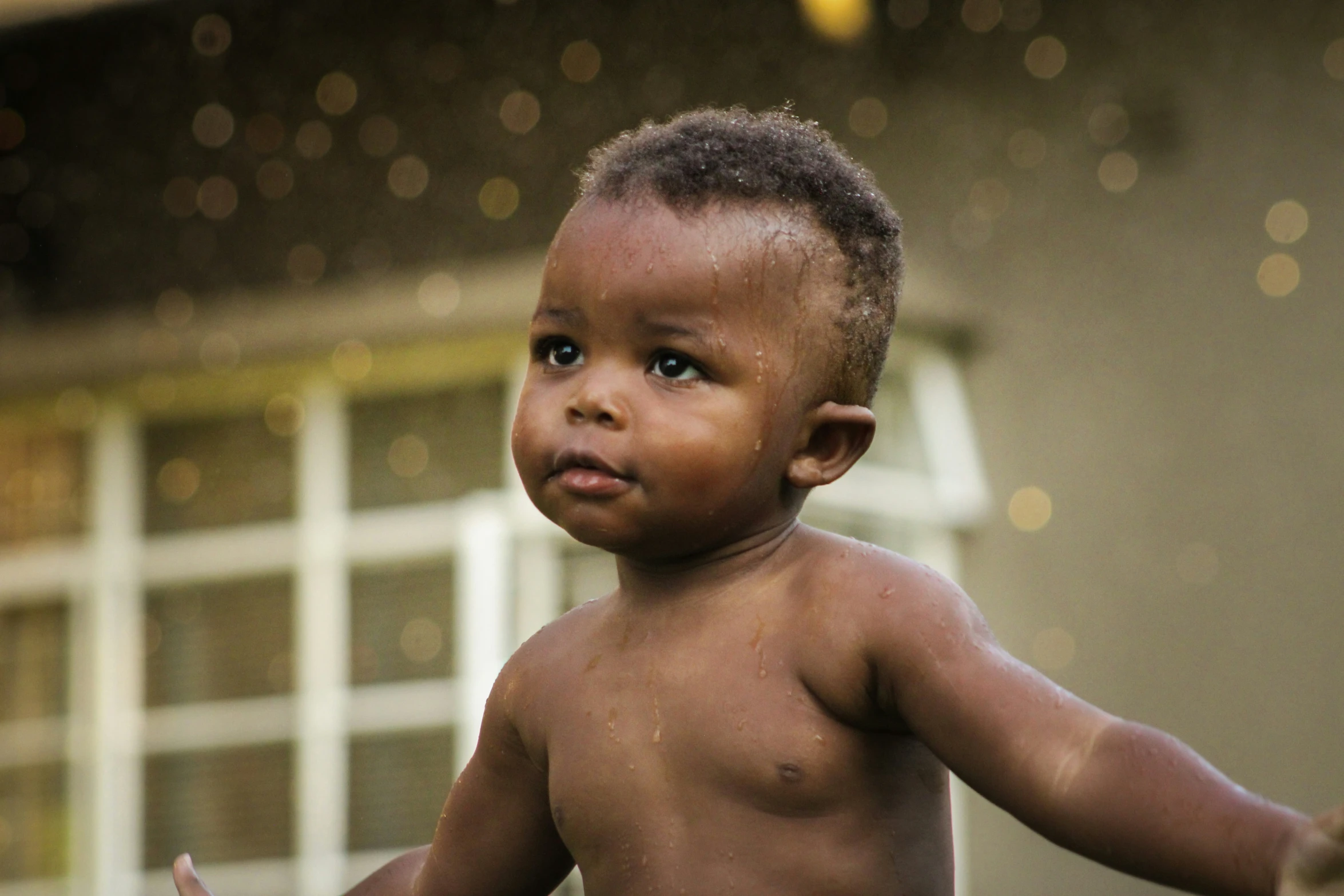 a baby standing outside looking forward with one leg raised