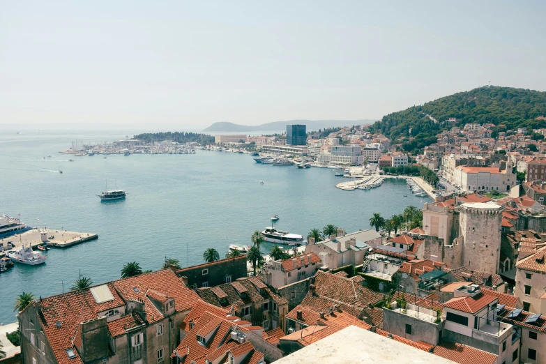 an aerial view of boats and buildings along the river in a city