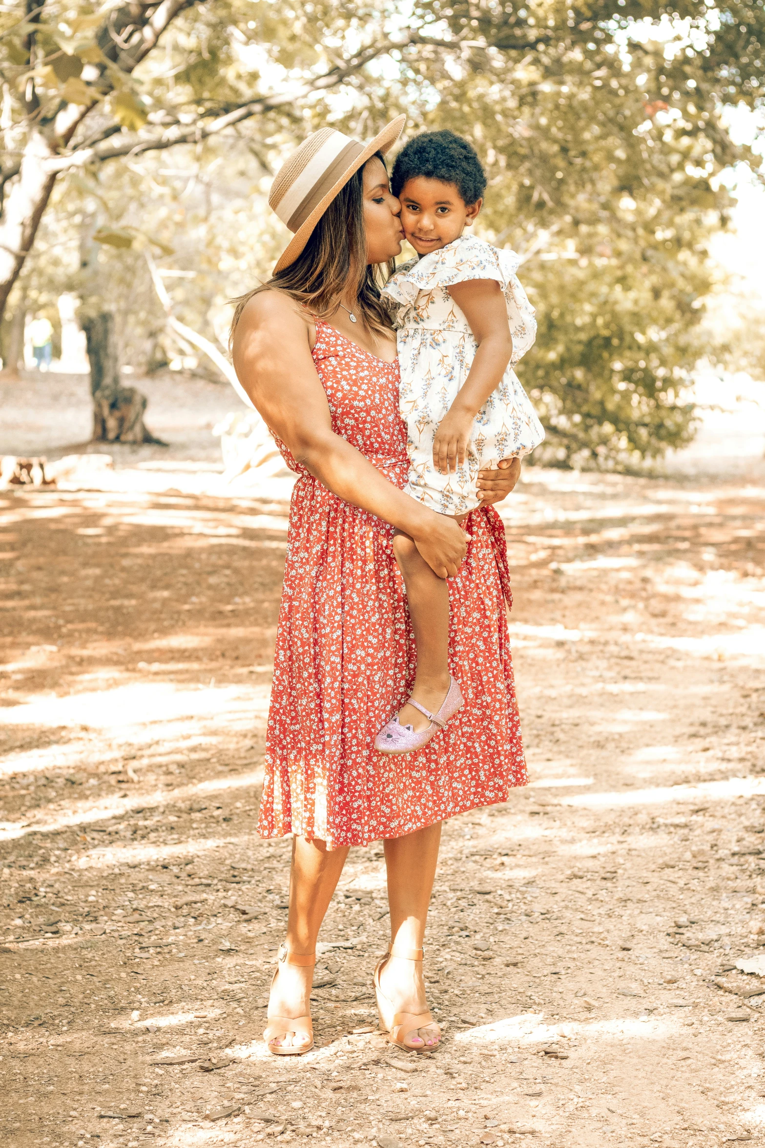 mother holding her toddler and hugging her daughter's shoulders