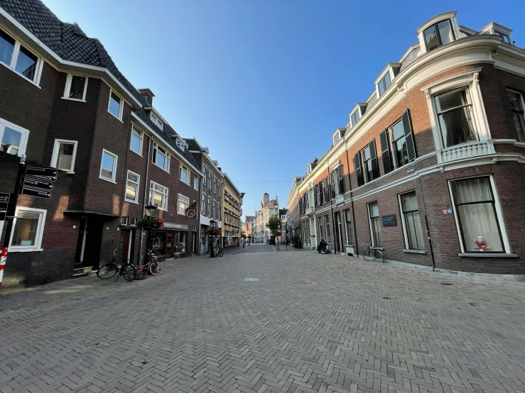 the empty street has many brown brick buildings on it