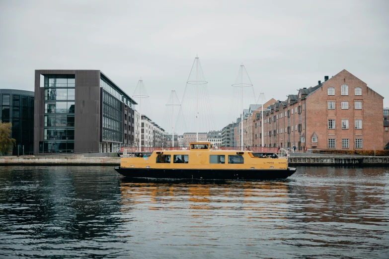 a yellow boat floating down a river next to tall buildings