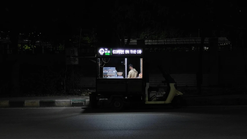 a truck driving down a street at night