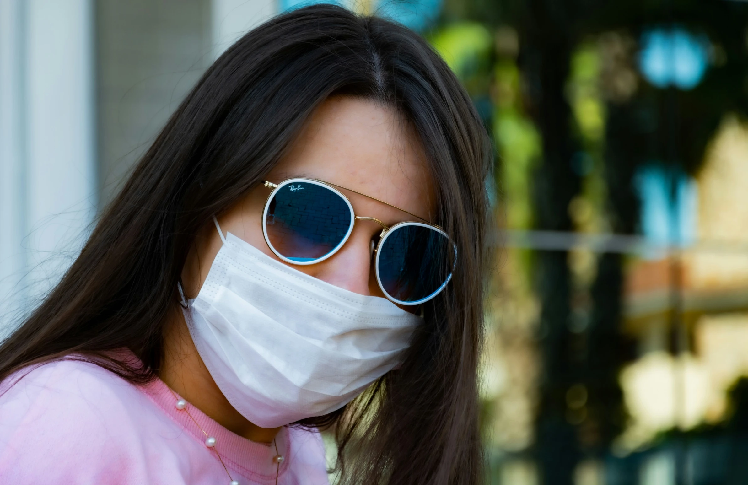 a woman wearing sun glasses and a mask to prevent the sun