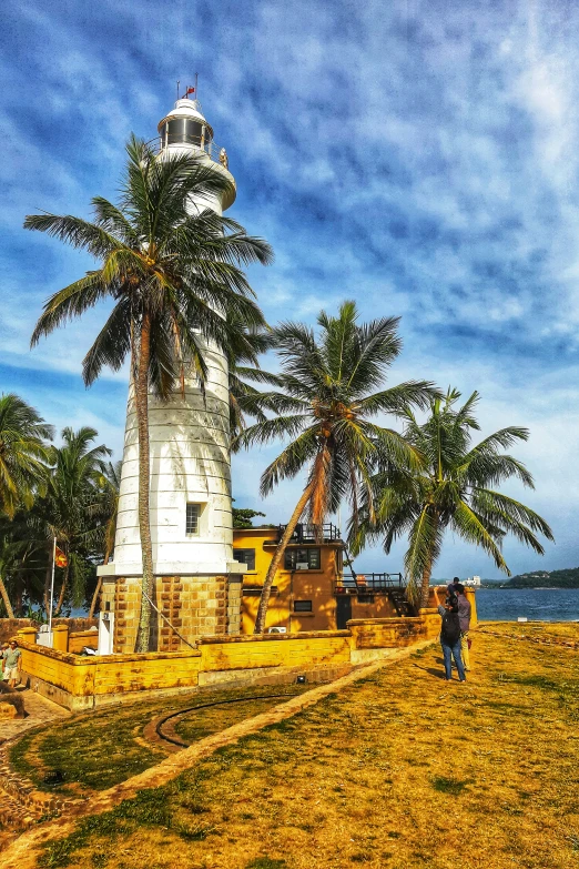 two people standing under palm trees on an island