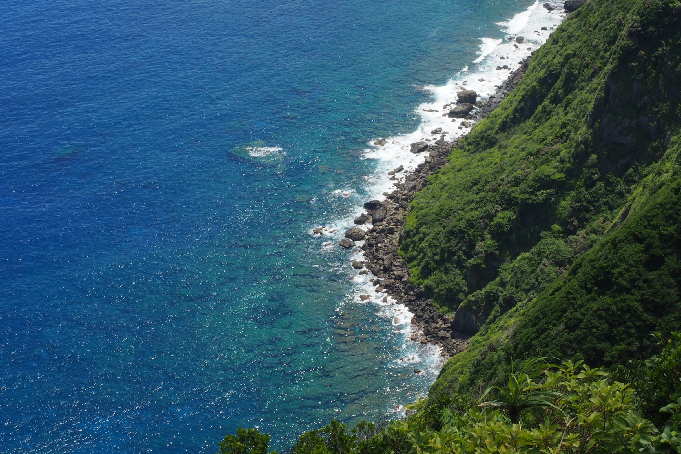 the rocky shore line of a beach next to the ocean