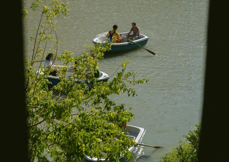 two boats that are on the water near some trees