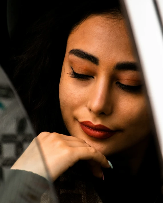 a woman that has her eyes closed while holding a cell phone