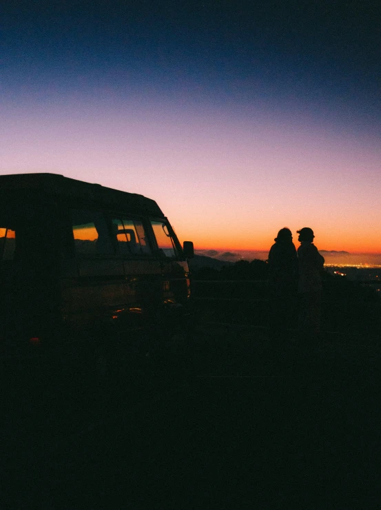 the back end of a van parked at sunset