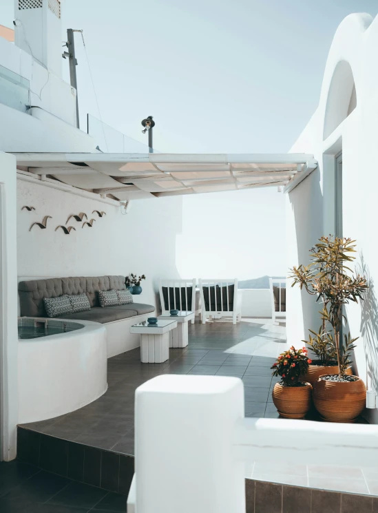 an outdoor area with a sofa and table and a potted plant