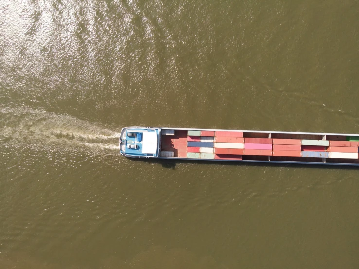 a long barge with colorful shipping containers passing by