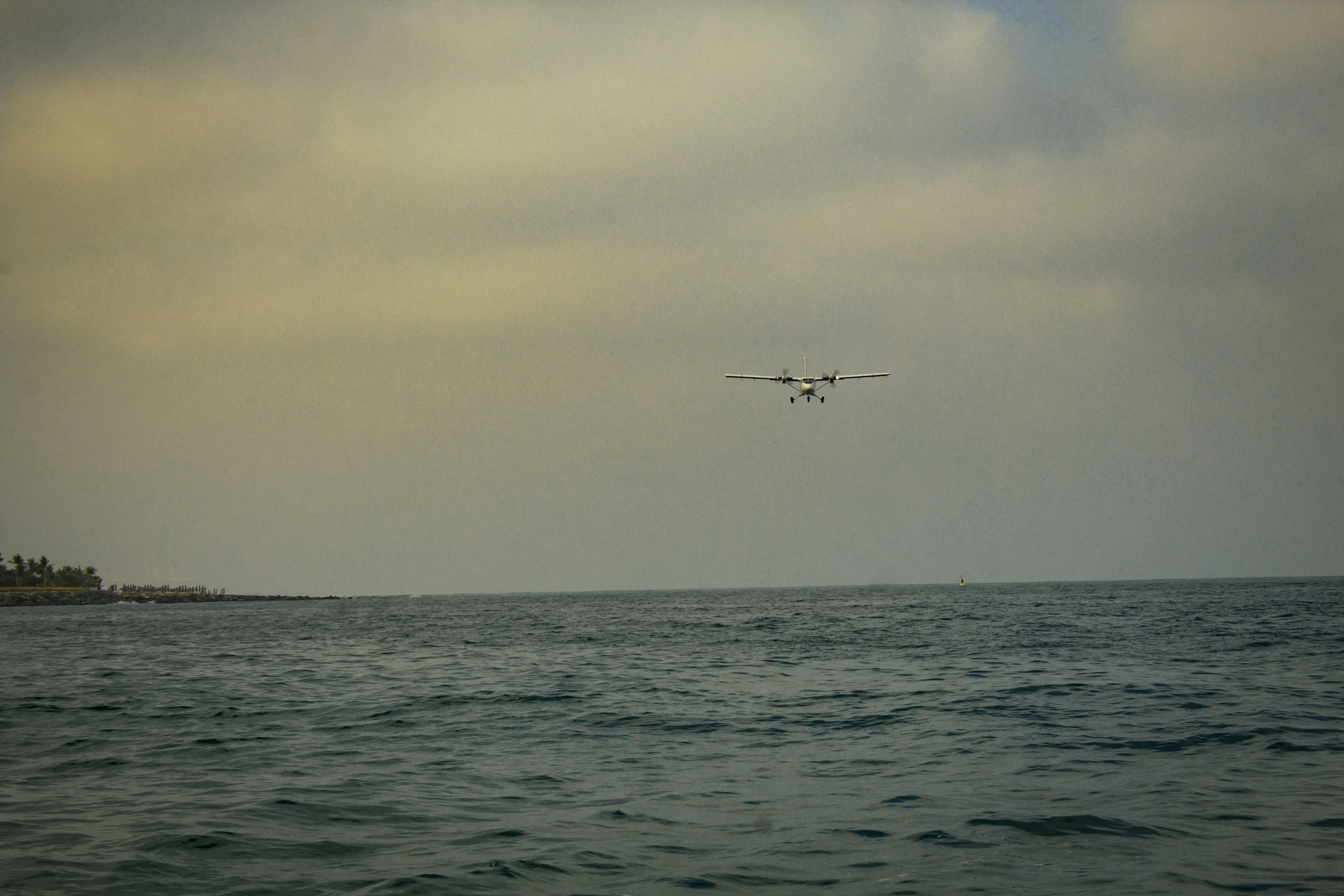 two planes flying over water with sky in the background