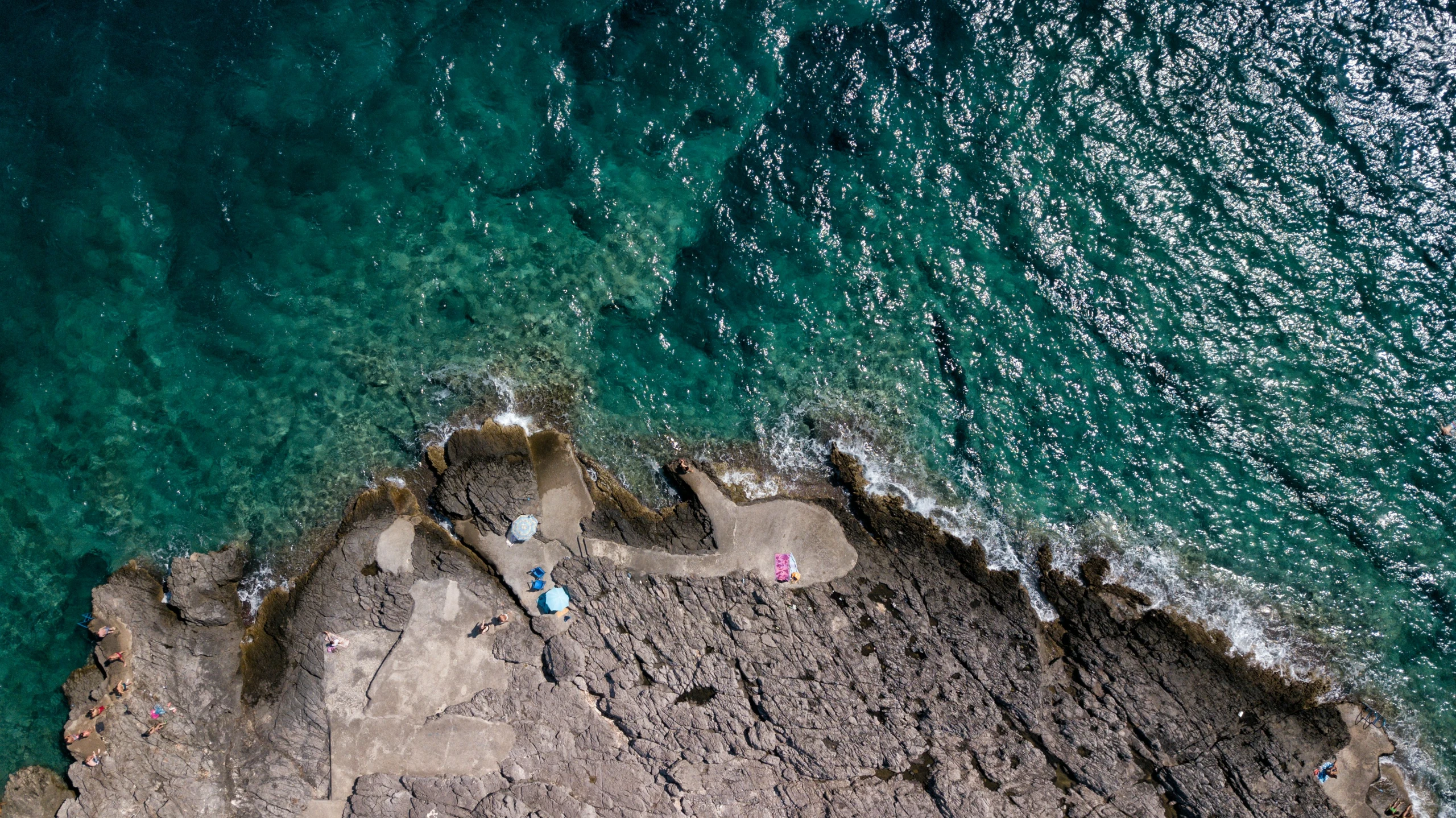 aerial s of man standing on rocks beside water