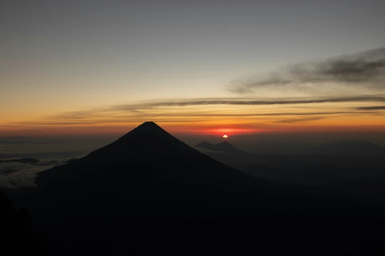 the sun is setting on top of a mountain