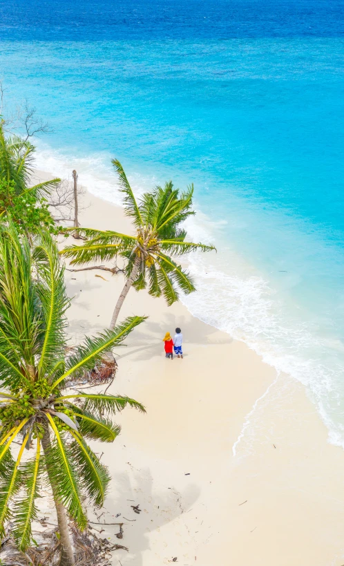 two people in red chairs on the white sand beach