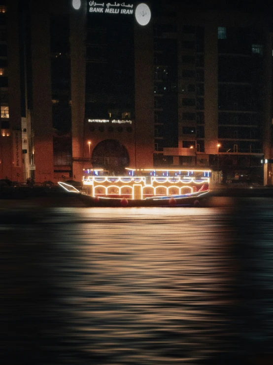 a long boat is floating by some buildings