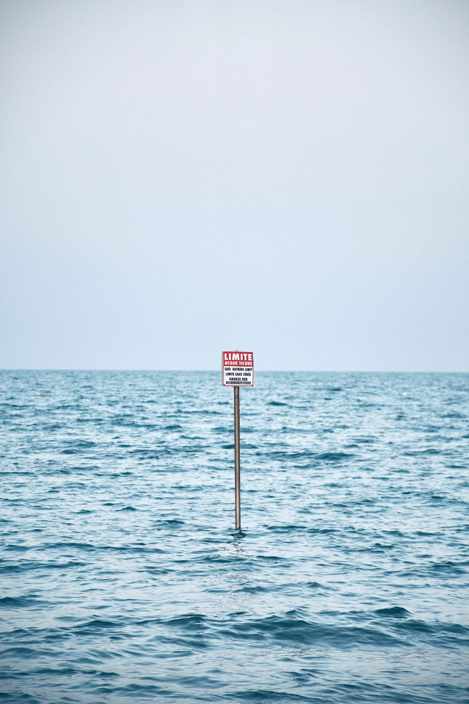 a sign on a pole in the middle of water