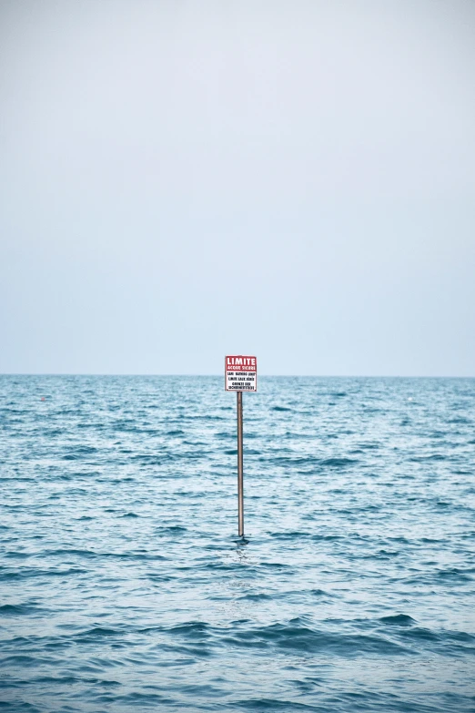 a sign on a pole in the middle of water