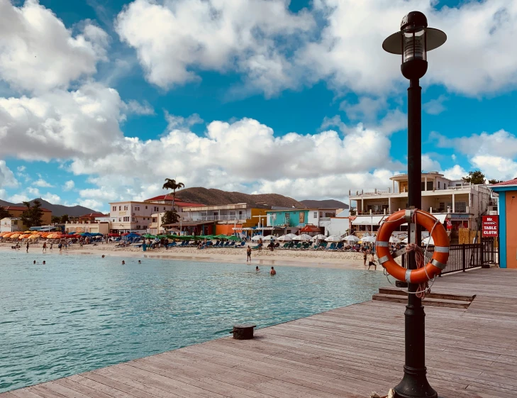 a life preserver sits on the dock in a busy beach town