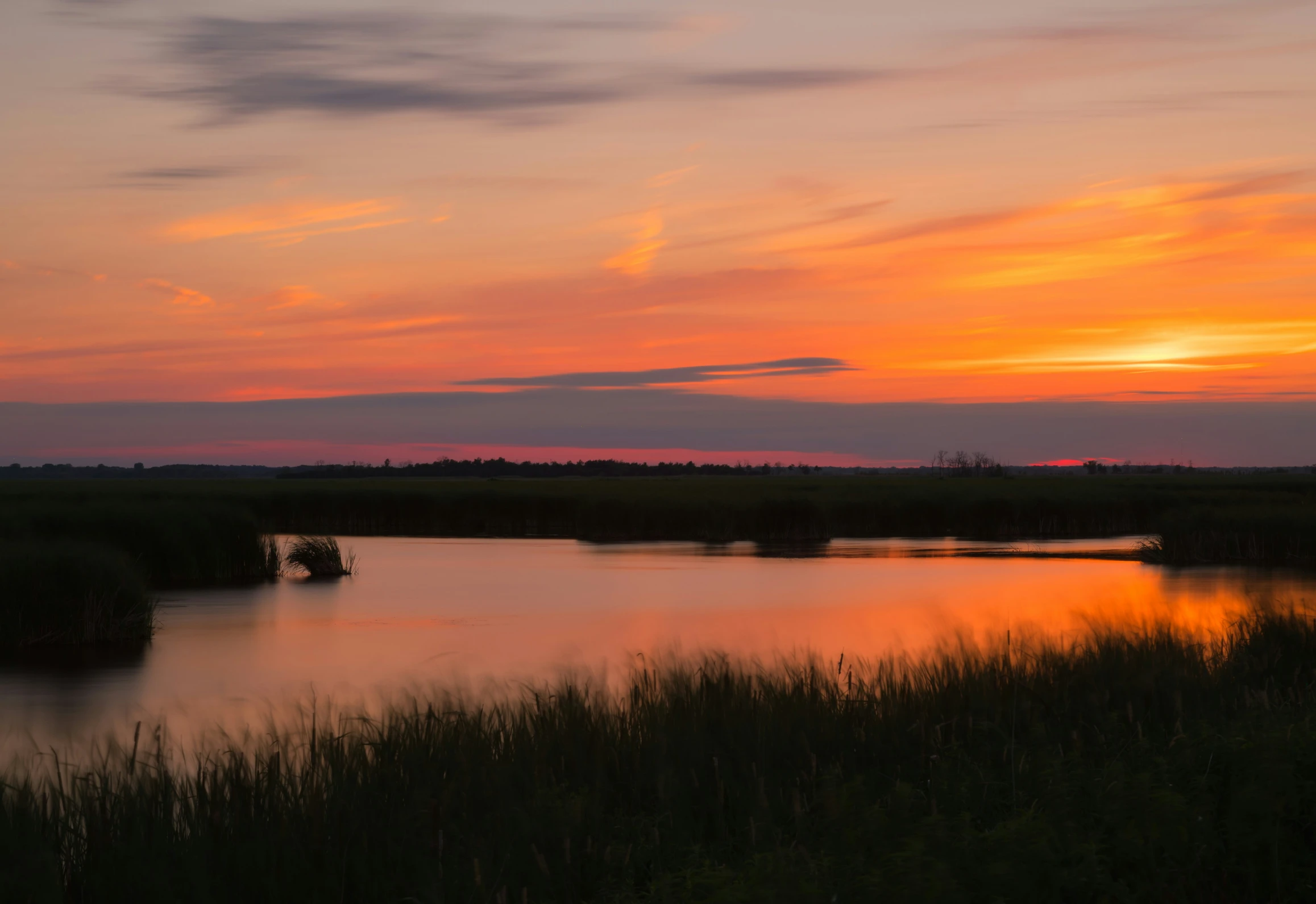 the sun is setting over the river with its calm waters