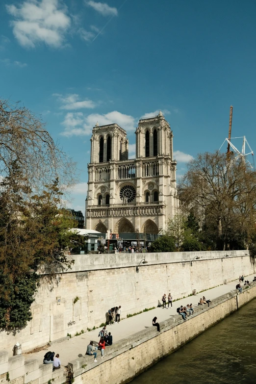 people on a bridge near a river by a building