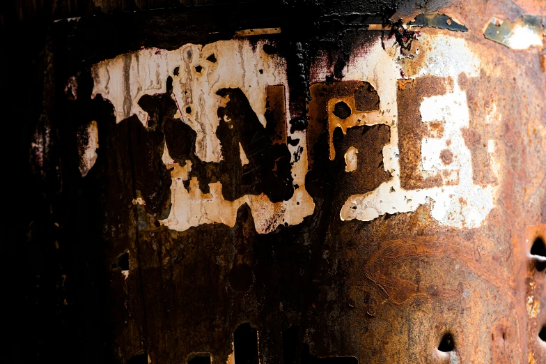 a rusted metal pole with some old words on it