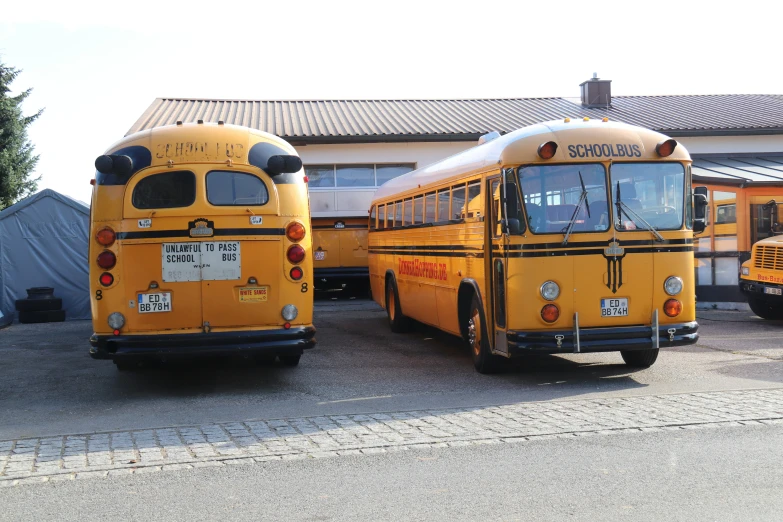 school buses parked in a parking lot next to a building