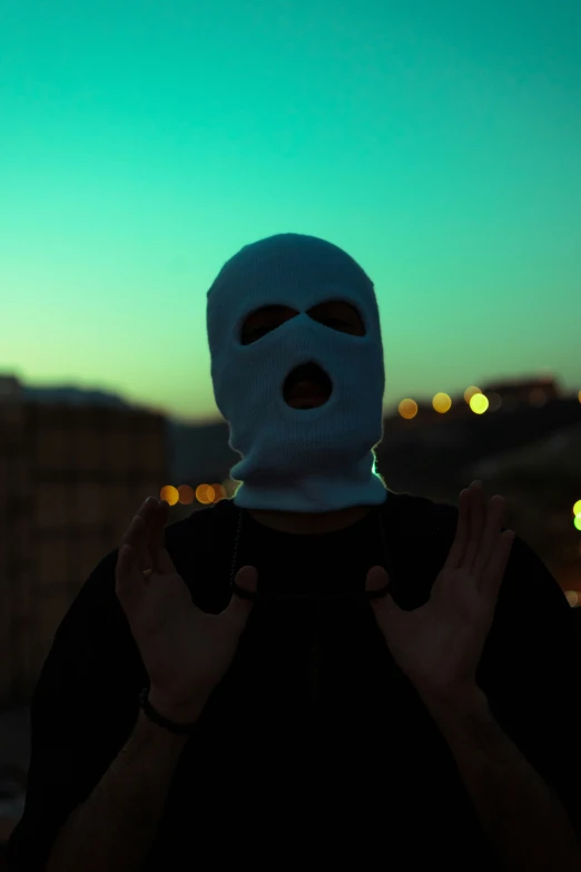 a man wearing a blue mask at dusk