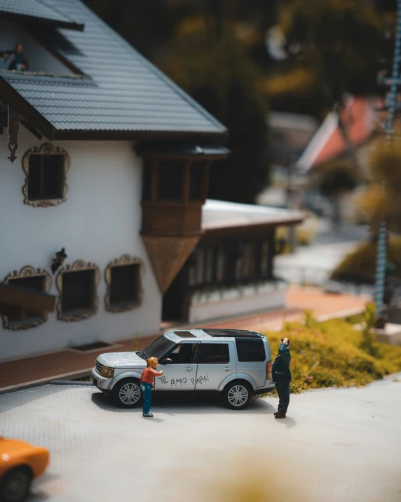 people stand in front of a model car