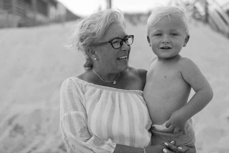 a woman holding her child on the beach