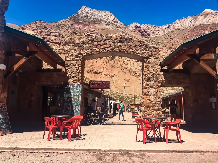 several chairs and tables at a cafe near mountains