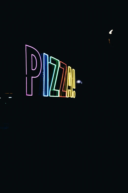 a lit up pizza sign in the dark