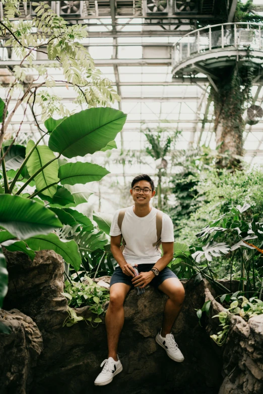 a man is sitting down in a tropical forest