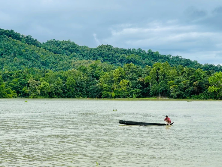 a man paddling a canoe across the water