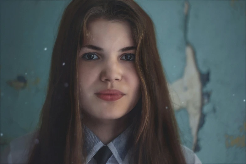 a girl with long brown hair standing in front of a painting