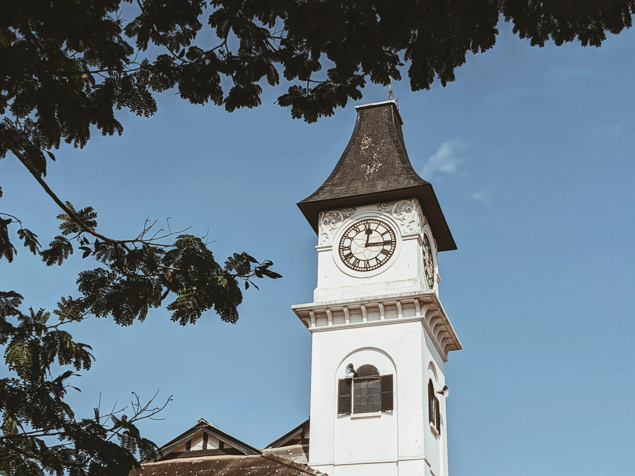 a white clock tower in the sky with a clock