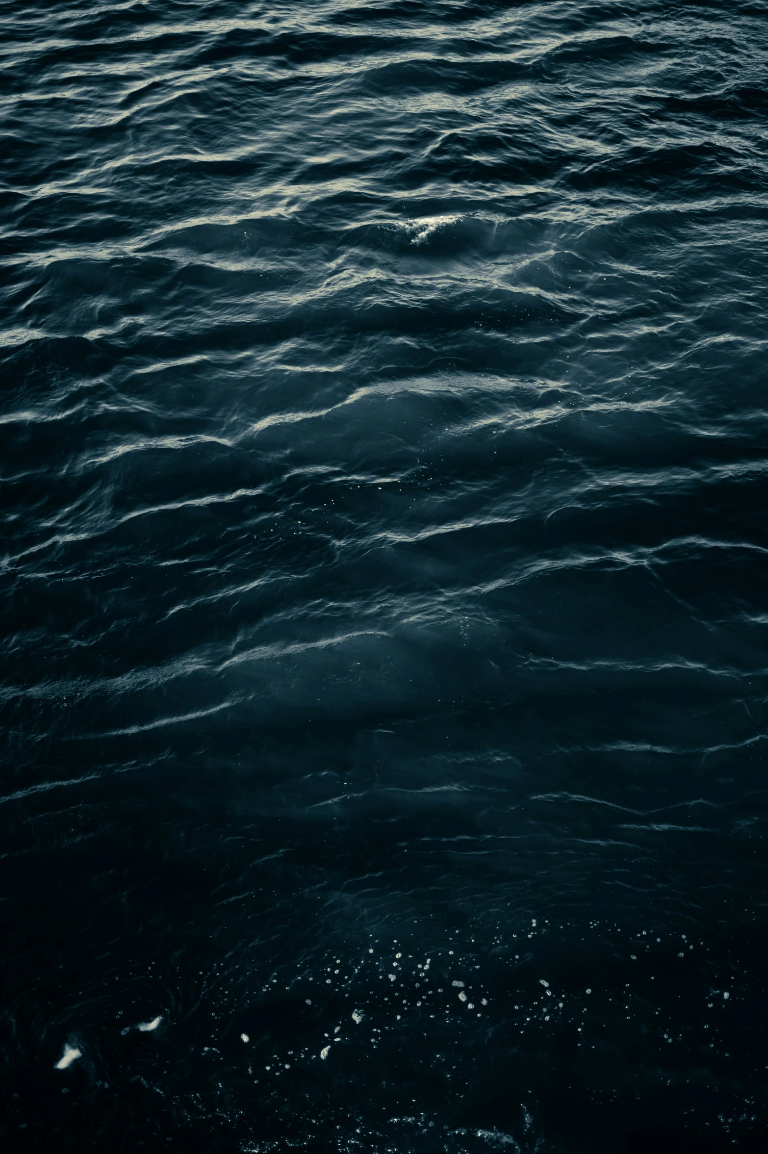 the ocean is very dark and deep with little waves